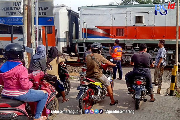 Perlintasa KA di Kecamatan Tirto, Gang 1, Pekalongan Barat, terpaksa dijaga secara manual. Lantaran palang pintu rusak. (Lutfi Hanafi/Jawa Pos Radar Semarang)
