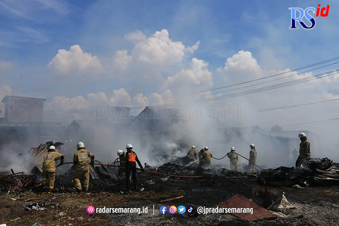 HANGUS TERBAKAR: Petugas Dinas Pemadam Kebakaran Kota Semarang menjinakkan api yang membakar gudang rosok di Tambakrejo, Semarang. (NURCHAMIM/JAWA POS RADAR SEMARANG)