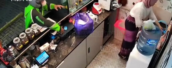 Detik-detik pelaku yang menyamar dengan memakai jaket ojek online, mencuri Iphone milik korban yang tengah sibuk melayani pesanan. (Ist)