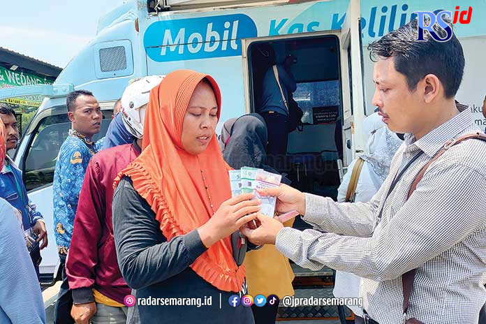 Warga menunjukkan uang baru yang baru saja didapatkannya dari menukarkan ke mobil kas keliling. (RIYAN FADLI/JAWA POS RADAR SEMARANG)