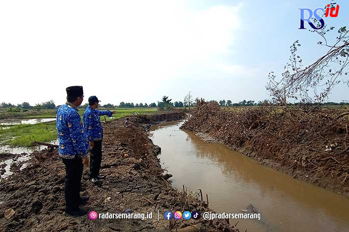 Camat Gringsing Adhi Bhaskoro dan Kades Krengseng Apriliyanto mengawasi langsung normalisasi Kali Tugu dan Kali Temiris di Desa Krengseng, Kecamatan Gringsing. (RIYAN FADLI/JAWA POS RADAR SEMARANG)