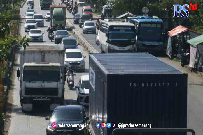 MACET PANJANG: Akibat rob tinggi di Sayung, Demak, menyebabkan kemacetan panjang di Jalan Kaligawe Raya, khususnya arus kendaraan dari arah Semarang menuju Demak. (NUR CHAMIM/JAWA POS RADAR SEMARANG)
