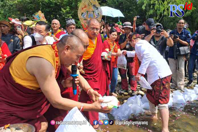 RITUAL PEMBEBASAN: Umat Buddha dari Majelis Umat Nyingma, Sangha Tantrayana melepaskan ribuan ekor ikan di Sungai Progo, Kabupaten Magelang, Jumat (2/6) kemarin. (ROFIK SYARIF/JAWA POS RADAR MAGELANG)