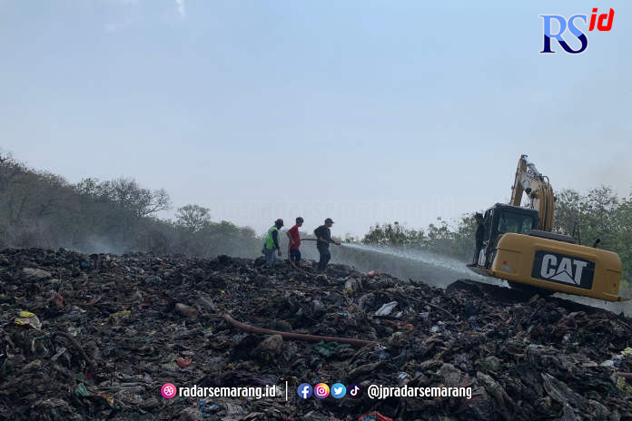 Petugas damkar terus melakukan penyemprotan air di eks TPA Darupono Minggu (18/6). (DEVI KHOFIFATUR RIZQI/ JAWA POS RADAR SEMARANG)