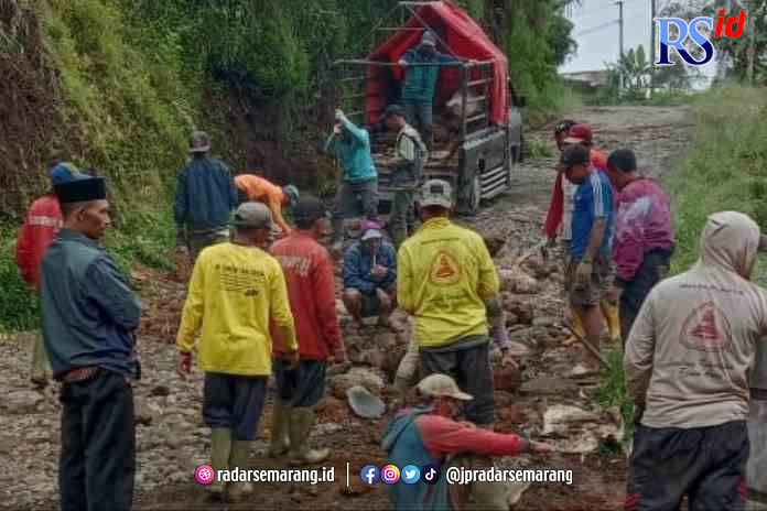 GOTONG-ROYONG: Warga Desa Simego gotong-royong memperbaiki jalan dengan pasir dan batu agar jalan bisa dilalui kendaraan.(NANANG/JAWA POS RADAR SEMARANG)