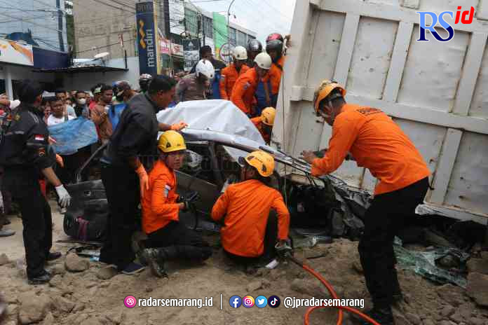 Petugas saat berusaha mengevakuasi Sola Gracia Ribka Utama saat terjebak di mobil yang tertimpa truk muatan batu Rabu (7/6) siang. (NURCHAMIM/JAWA POS RADAR SEMARANG)