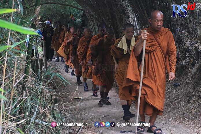 Para bhante atau biksu thudong saat melintasi jalanan di wilayah Gunungpati Kota Semarang Senin (29/5). (NURCHAMIM/JAWA POS RADAR SEMARANG)