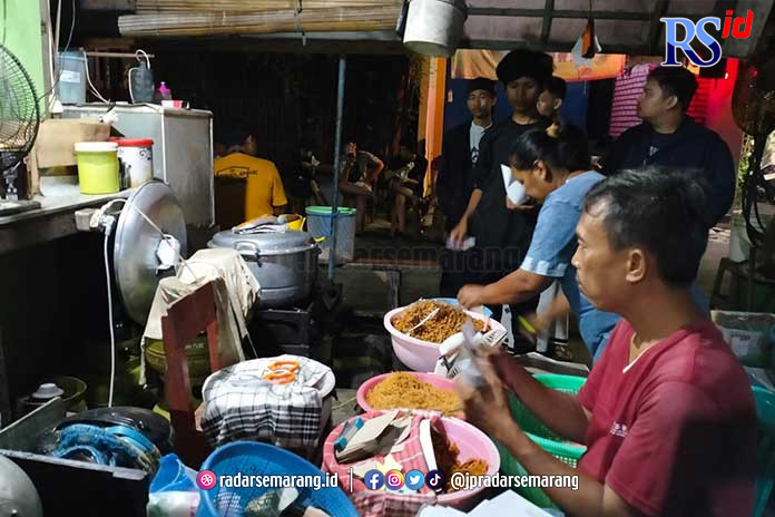 Suyanto sedang melayani pembeli sego usus di tengah malam. (FIGUR RONGGO WASSALIM/JAWA POS RADAR SEMARANG)