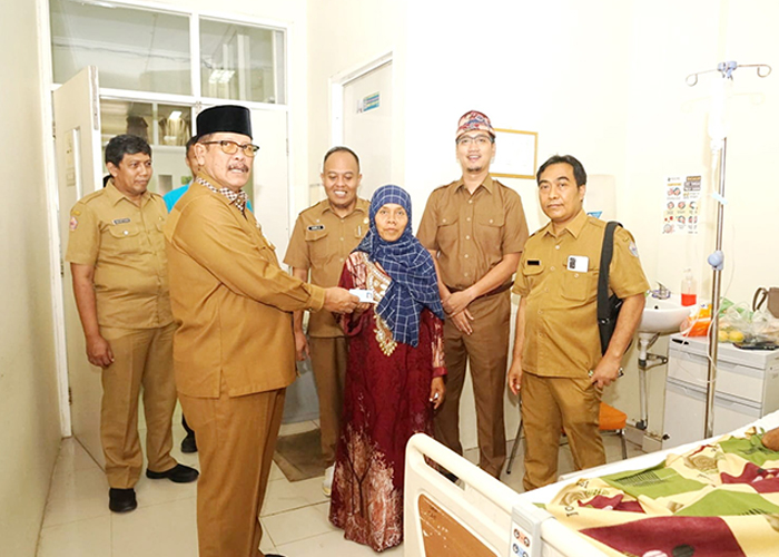 DIPERMUDAH: Plt Bupati Bangkalan Mohni menyerakan e-KTP kepada salah satu keluarga pasien di RSUD Syamrabu, Selasa (20/6).