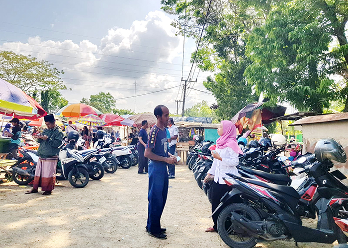 TERTIB: Petugas dishub menyerahkan karcis kepada pengunjung Pasar Kolpajung.&nbsp;