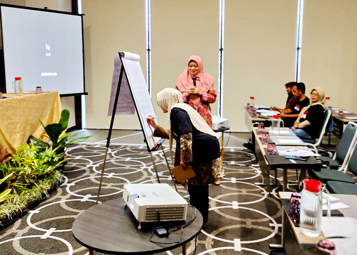 RAWAT: Yuyun (memegang mik) menjadi narasumber di pelatihan revitalisasi bahasa Madura di Surabaya, Senin (29/5).&nbsp;