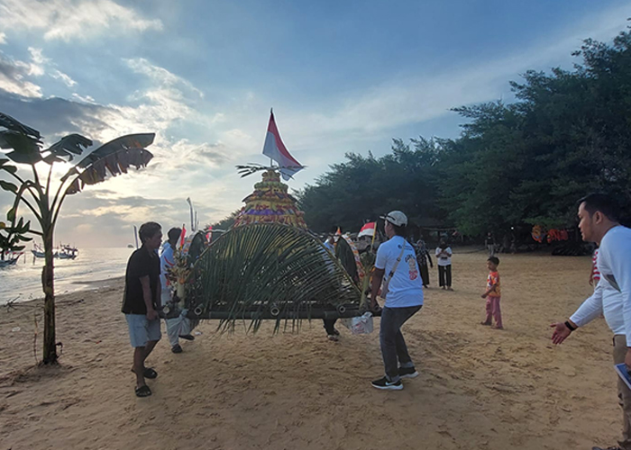 KOMPAK: Warga menggotong larung sesaji yang akan dilepas ke laut pada acara rokat tase di Pantai Lon Malang, Desa Bira Tengah, Kecamatan Sokobanah, Sampang, Minggu (16/7).&nbsp;