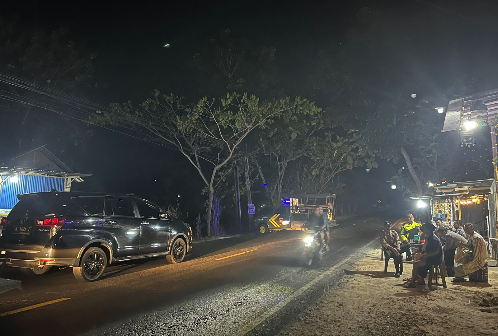 Polisi berjaga di lokasi penutupan jalur di Dusun Angsana, Desa Galis, Kecamatan Galis, Bangkalan, Jumat (21/7). (DAFIR FALAH/JPRM)