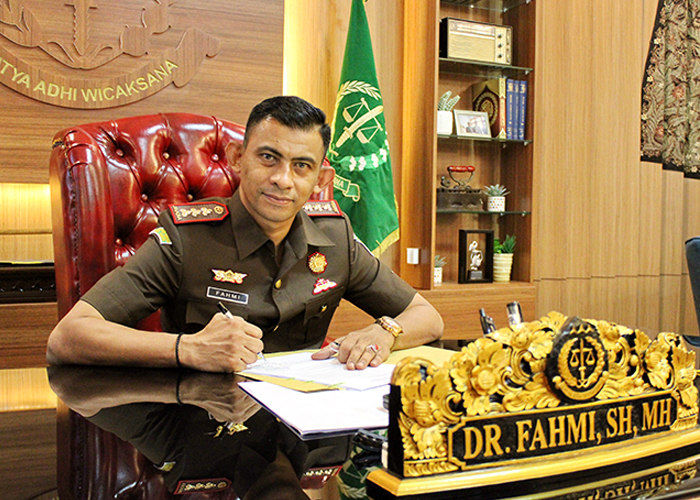 PIMPINAN: Kajari Bangkalan Fahmi menandatangani berkas di ruang kerjanya.&nbsp;