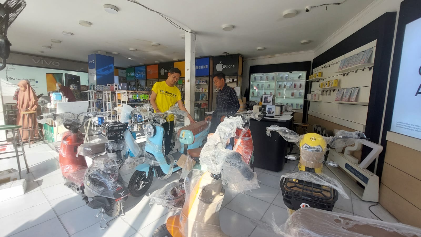 Bagian Penjualan Toko HP Mart Cabang Sampang Slamet Riyadi (kaus kuning) menunjukkan sepeda listrik yang dijual di tokonya Kamis (3/8).