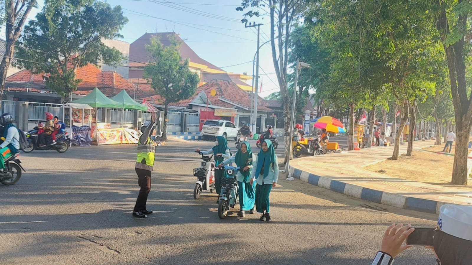 Polisi lalu lintas ketika mengawal siswa yang menggunakan sepeda listrik ke sekolahnya di SMP Negeri 1 Sampang Kamis (3/8).