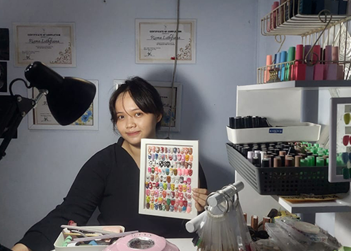 FASILITAS LENGKAP: Risma Lutfiana memasang nail art di tempat usahanya di Jalan Raya Telang Indah, kamal.&nbsp;