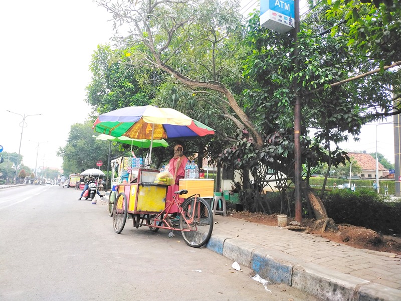 HAMBAT LALIN: PKL berjualan di depan RSUD Syamrabu, Jalan Pemuda Kaffa, Bangkalan, Minggu (6/8). (VIVIN AGUSTIN HARTONO/JPRM)