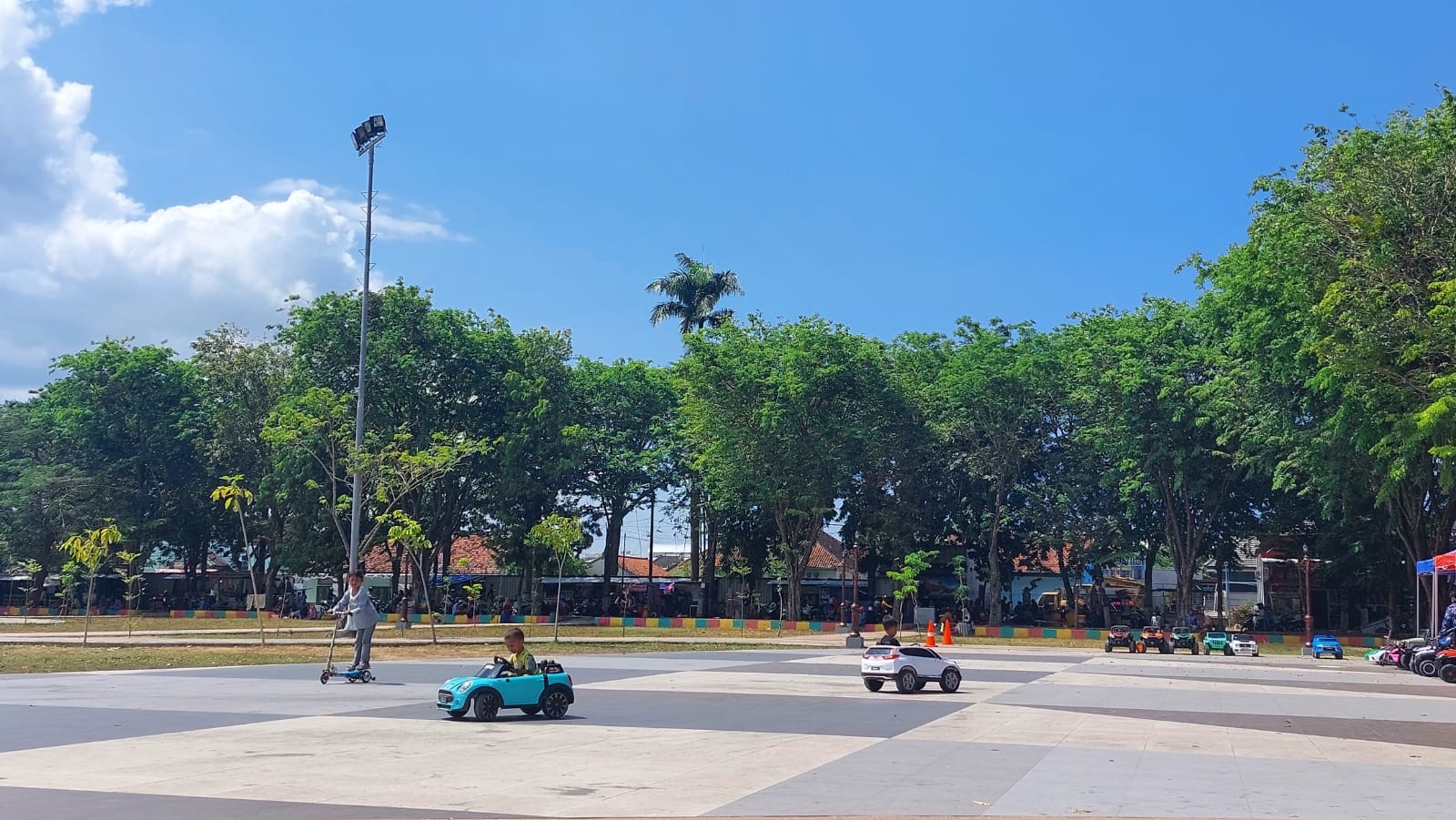 CERIA: Anak-anak asyik bermain kendaraan listrik di area Alun-Alun Trunojoyo, Sampang, Minggu (6/8). (JUNAIDI PONDIYANTO/JPRM)