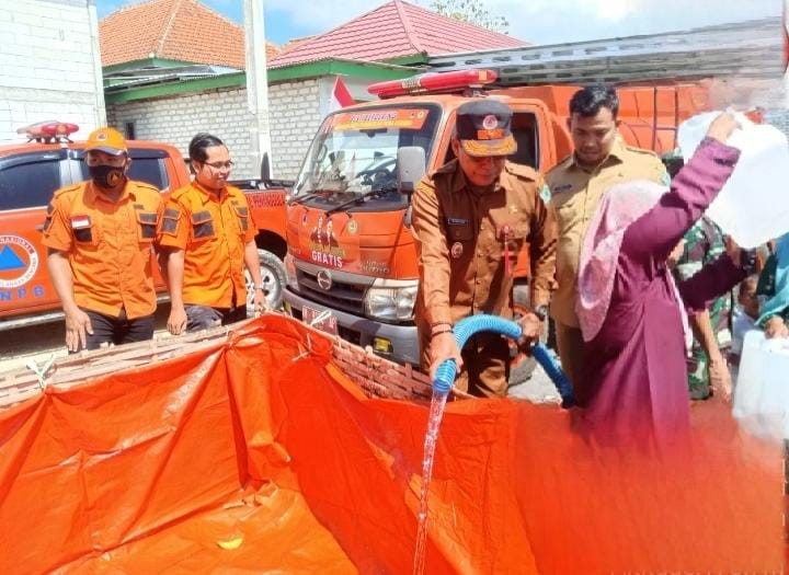 PENYALURAN: Kalaksa BPBD Pamekasan Rusdiyadi (pakai topi) dan Sekretaris BPBD Akhmad Dhofir Rosidi saat proses pendistribusian air bersih di Desa Ragang, Kecamatan Waru, Pamekasan, Senin (7/8).