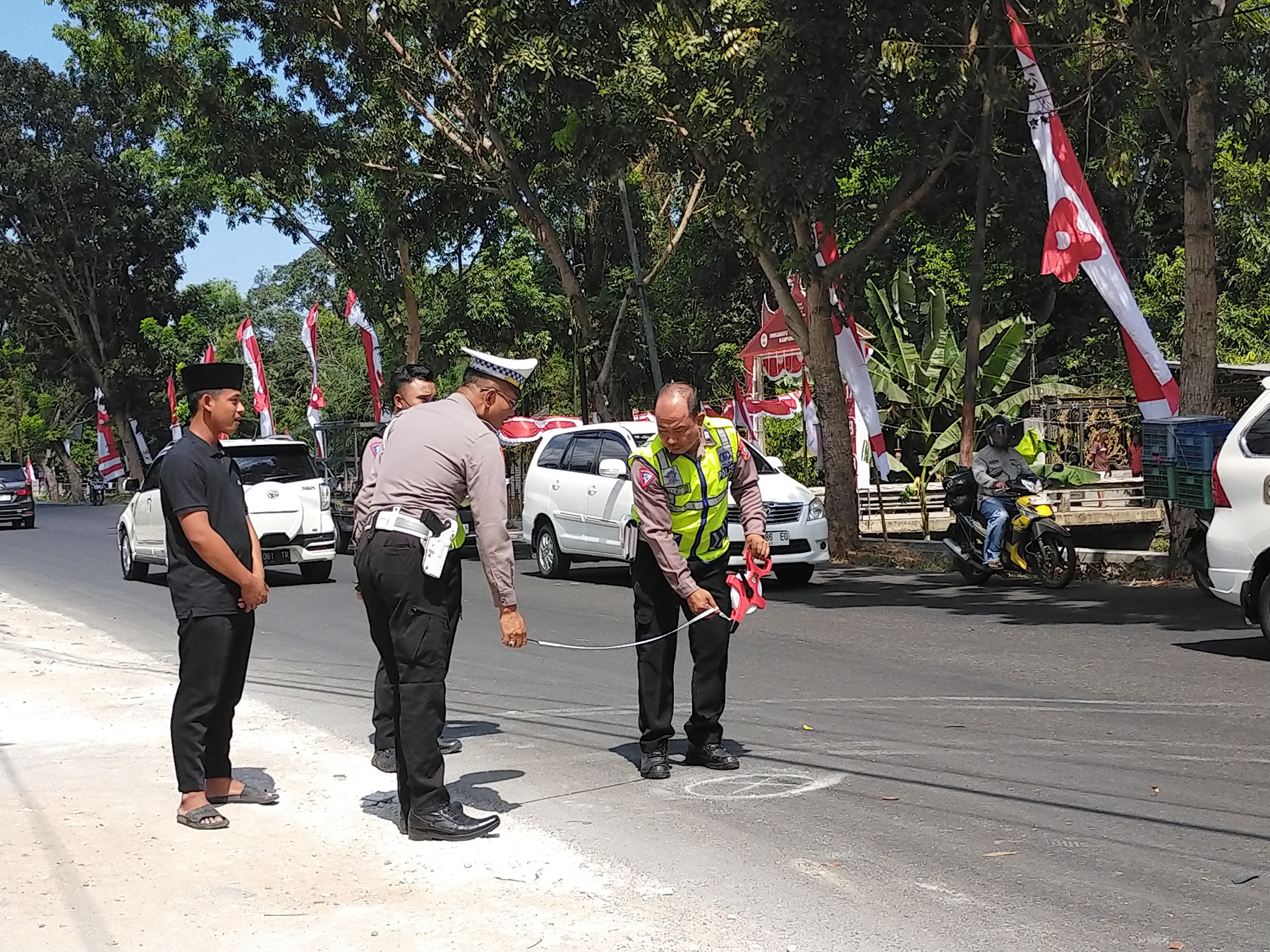 Riski Maulana (kiri) menyaksikan polisi melakukan olah tempat kejadian perkara kecelakaan lalu lintas di Jalan Raya Ketengan, Kelurahan Tanjung, Kecamatan Burneh, Bangkalan, Selasa (8/8).