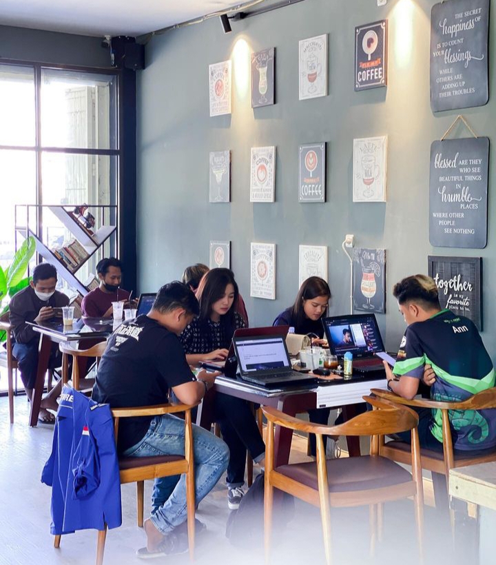 Pengunjung menikmati kopi sembari mengoperasikan laptop di  Basecamp Cafe.