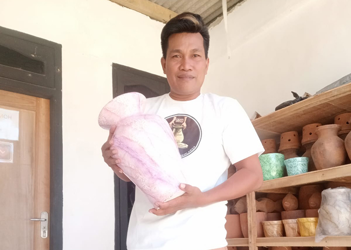 PRODUKTIF: Syafiuddin menunjukkan hasil kerajinan gerabah berupa vas bunga yang diproduksinya di Desa Tlambah, Kecamatan Karang Penang, Sampang.