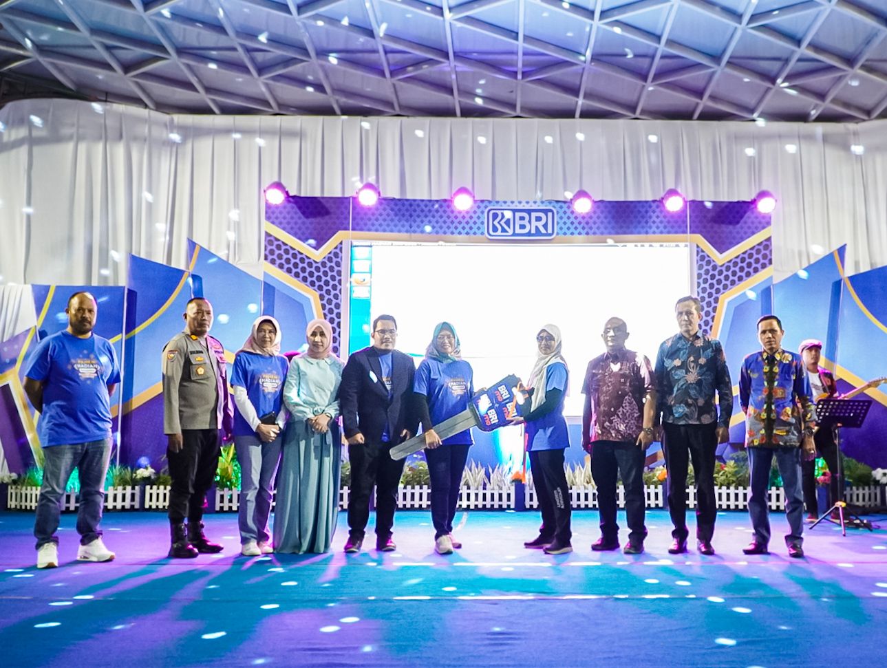 MERIAH: Pemimpin BRI Cabang Sampang Rahmat Salim (lima dari kiri) dan tim menyerahkan undian PHS di area GOR Taman Wijaya Kusuma, Sabtu (12/8) malam. (BRI UNTUK JPRM)