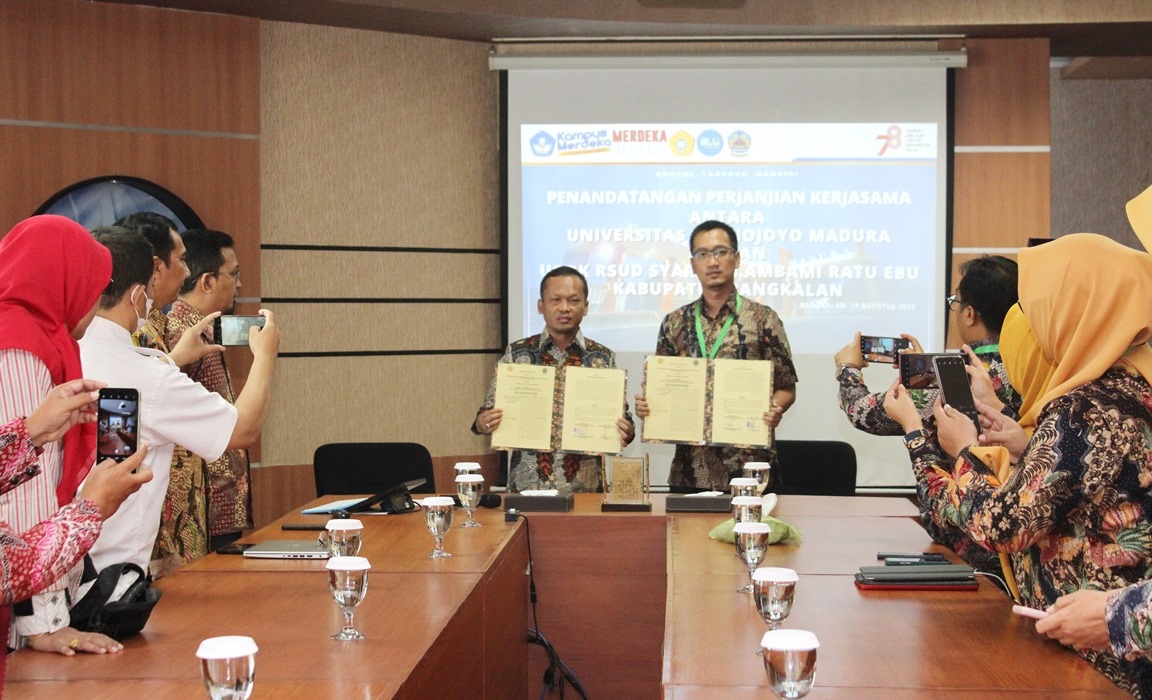 BERMITRA: Rektor UTM Safi&rsquo; (kiri) dan Plt Direktur RSUD Syamrabu Farhat Suryaningrat menunjukkan dokumen perjanjian kerja sama yang telah ditandatangani Jumat (18/8). (VIVIN AGUSTIN HARTONO/JPRM)