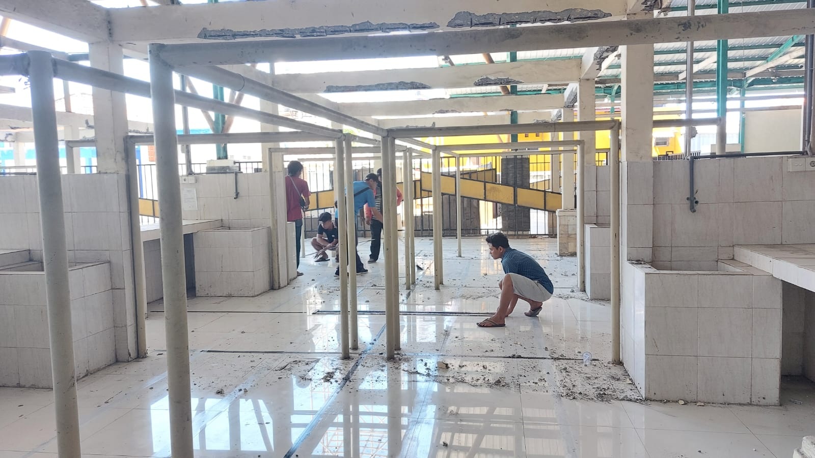 SIBUK: Pekeja saat memasang garis sekat di Pasar Margalela yang beralamat di Jalan Syamsul Arifin, Kota Sampang, Minggu (20/8). (JUNAIDI PONDIYANTO/JPRM)