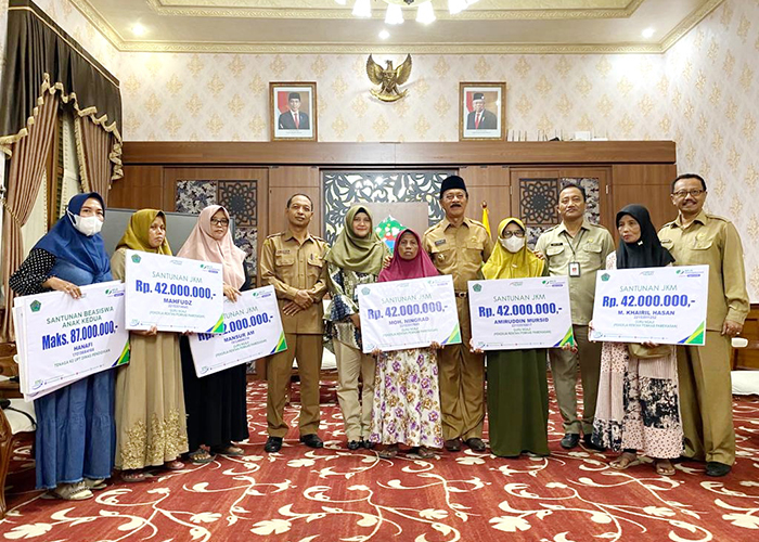 BERMANFAAT: Kepala BPJS Ketenagakerjaan Pamekasan Anita Ardhiana (lima dari kiri) foto bersama Wakil Bupati Pamekasan Fattah Jasin seusai menyerahkan santunan JKM kepada masing-masing penerima.