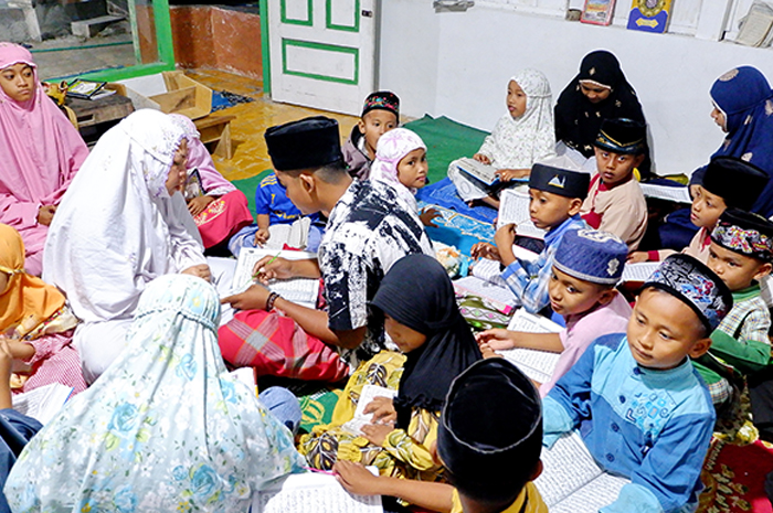 SABAR DAN TELATEN: Wardatus Sa&rsquo;adah menjadi tumpuan anak-anak Dusun Tongoh Barat, Desa Pangongsean, Kecamatan Torjun, Sampang, untuk belajar mengaji. (MOH. IQBAL AFGANI/JPRM)