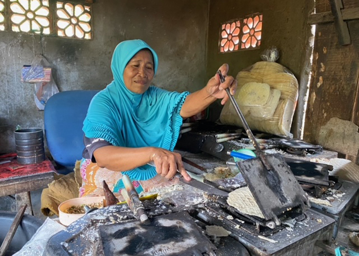 TURUN-TEMURUN: Juhairiah mengadonankan kerupuk gambir di warungnya di Dusun Dungendak, Desa Tlontoraja, Kecamatan Pasean, Pamekasan, Sabtu (19/8). (AYU LATIFAH/JPRM)