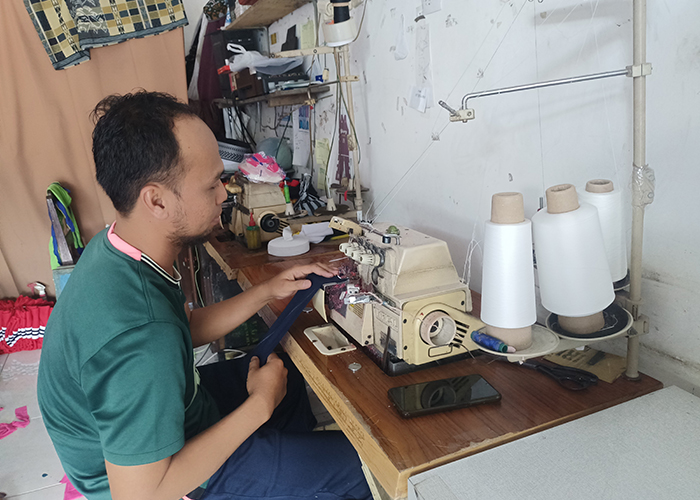 SUKSES: Sudarsono membuat baju sekolah di tempat usaha di Desa/Kecamatan Batuan, Sumenep, Sabtu (19/8). (MOH. IQBAL/JPRM)