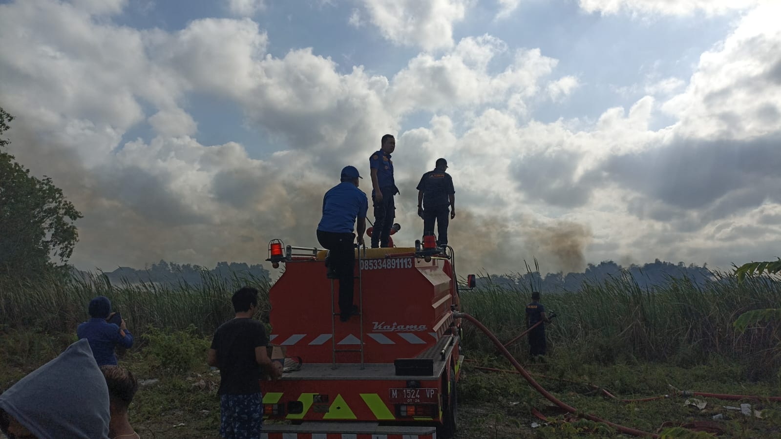 KERJA TIM: Kru damkar berjuang memadamkan api di lahan kosong yang ada di Desa Kolor, Kecamatan Kota Sumenep, Rabu (30/8). (H. SUBIYAKTO UNTUK JPRM)
