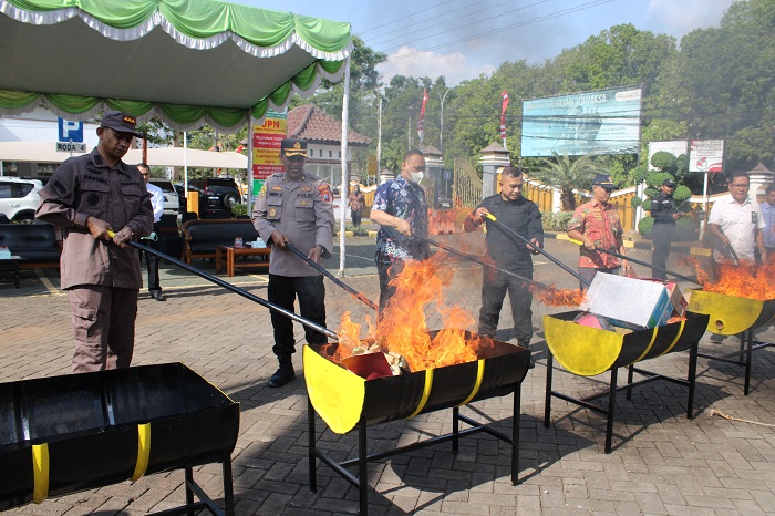 HANGUS: Kajari Bangkalan (kiri) Fahmi bersama-sama undangan membakar barang bukti tindak pidana di halaman kantornya, Kamis (31/8). (VIVIN AGUSTIN HARTONO/JPRM)