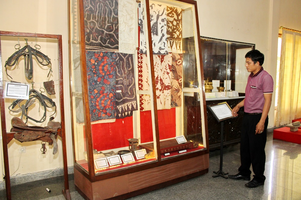 BUKTI SEJARAH: Juru pelihara Museum Cakraningrat Bangkalan Abd. Rohman memperlihatkan koleksi batik, Rabu (23/8). (VIVIN AGUSTIN HARTONO/JPRM)
