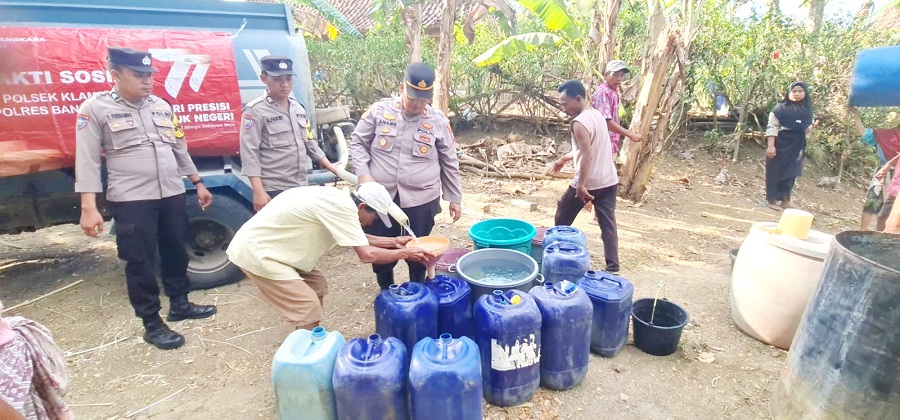 PEDULI: Kapolsek Klampis Iptu Anang Widiari didampingi dua anggotanya mendistribusikan air bersih kepada warga Desa Bragang, Bangkalan, Jumat (1/9). (HUMAS POLRES UNTUK JPRM)