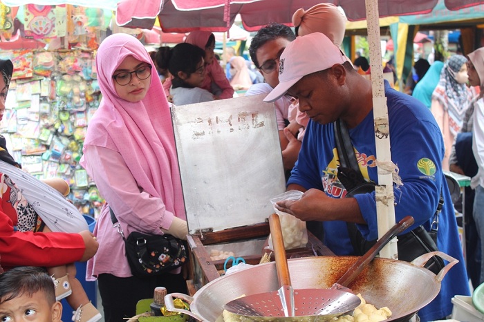 MAMIN: Warga mengunjungi stan yang menjajakan makanan minuman di area CFD Taman Bunga Pottre Koneng, Sumenep, Minggu (3/9). (ERWIN MAULIDIN MAASBACH/ JPRM)