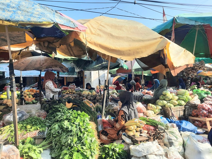 BERANTAKAN: Warga berjualan di Pasar Waru hanya dengan menggunakan tenda payung, Kamis (7/9). (MOH. JUNAIDI/JPRM)