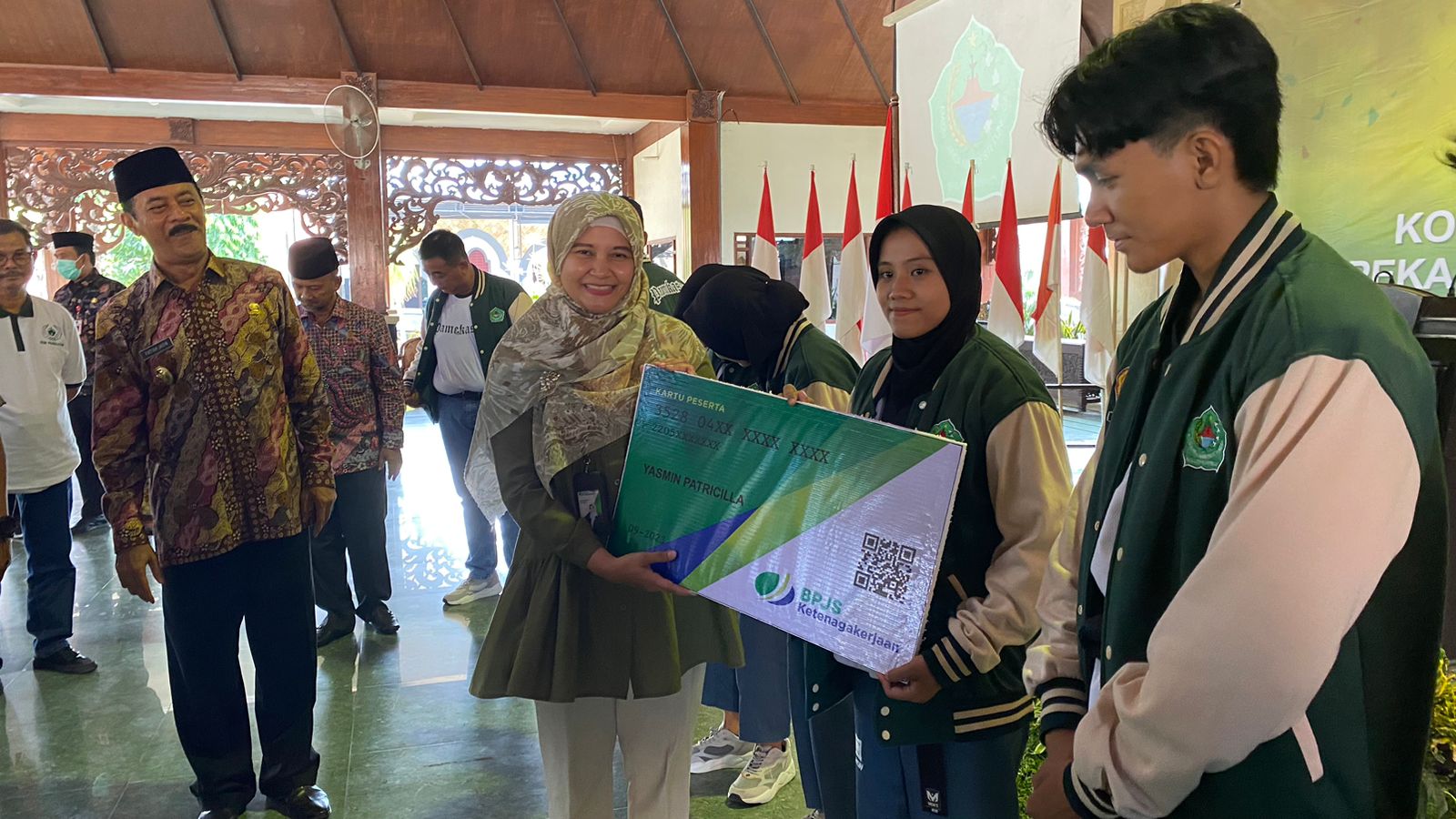 PERLINDUNGAN: Kepala BPJS Ketenagakerjaan Pamekasan Anita Ardhiana didampingi Wabup Pamekasan Fattah Yasin memberikan kartu BPJS kepada atlet secara simbolis di Pendapa Agung Mandhapa Ronggosukowati.
