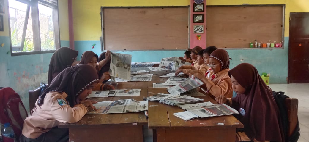 FOKUS: Siswa kelas V SDN Ngabab 3, Desa Ngabab, Kecamatan Pujon, Malang, mengamati macam-macam peristiwa di dalam koran, Sabtu (9/9). (INA HERDIYANA/JPRM)