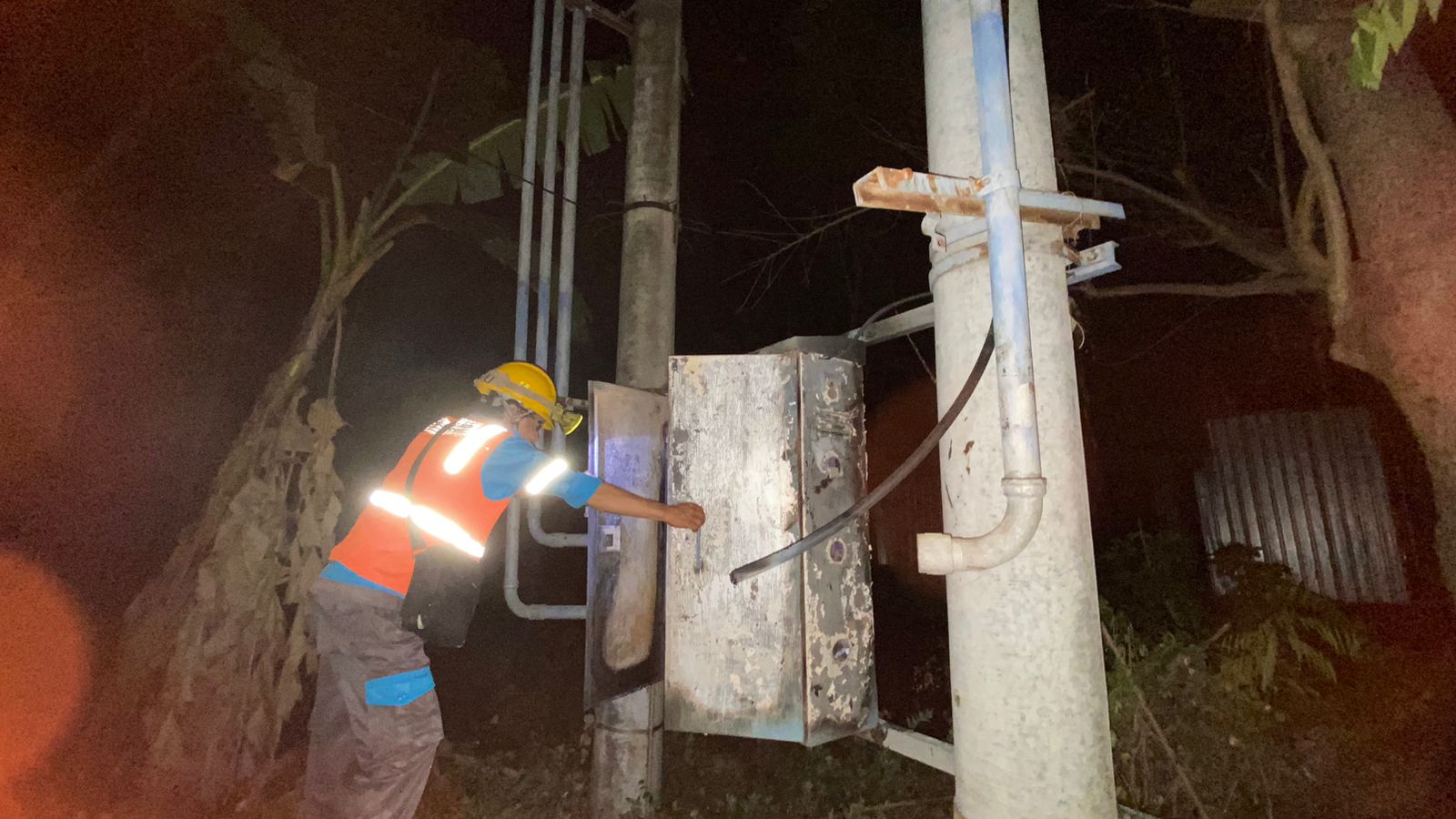 WASPADA: Teknisi PLN UP3 Pamekasan Sasmito sedang melihat kondisi GTT di Desa Berenta Tinggi, Kecamatan Tlanakan, Pamekasan pada Rabu (13/9) malam. (AYU LATIFAH/JPRM)