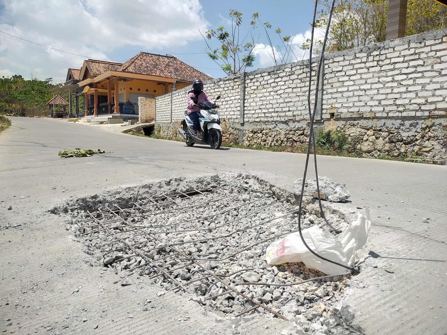 DIPERBAIKI: Pengendara melintas di samping jalan rusak akses Jalan Kotah-Tambelangan yang dibongkar Selasa (12/9). (ANIS BILLAH/JPRM)