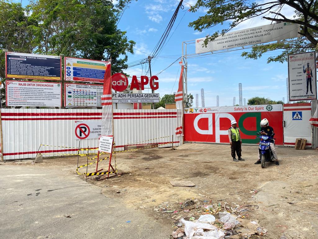 TIDAK TRANSPARAN: Petugas satpam berbincang dengan warga di area pembangunan Pasar Kolpajung, Pamekasan, Kamis (14/9). (MOH. JUNAIDI/JPRM)
