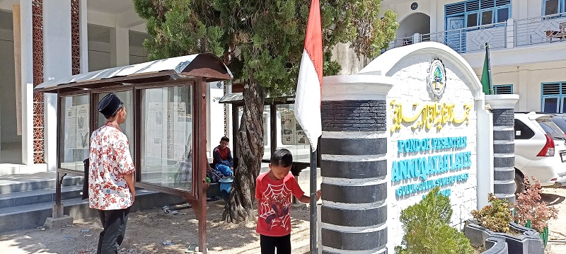 CINTA TANAH AIR: Majdi membaca koran di Pondok Pesantren Annuqayah Daerah Latee, Minggu (30/7). (LUKMAN HAKIM AG./JPRM)