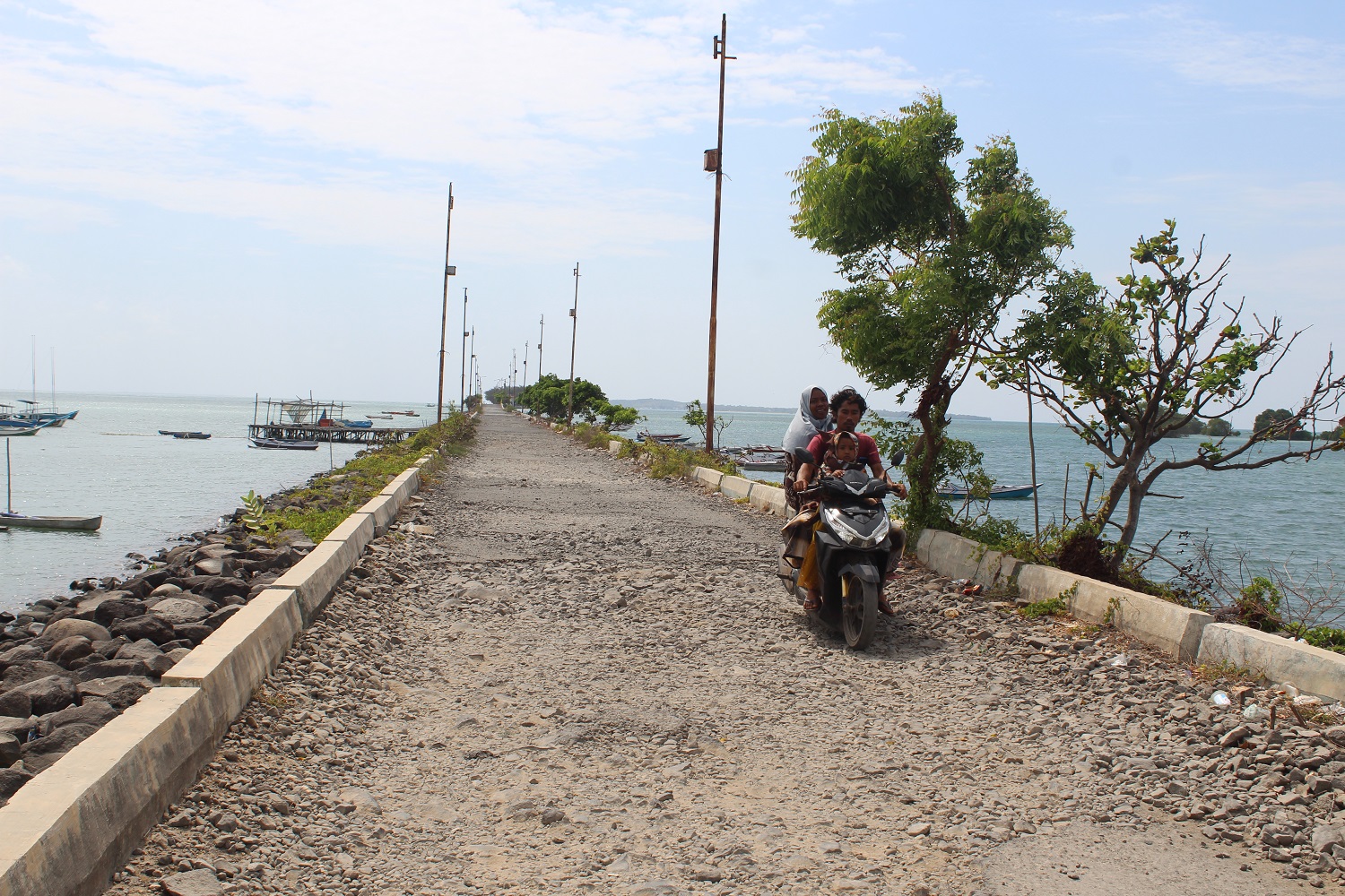 BUTUH PERBAIKAN: Pengendara motor melintas di akses Jalan Dermaga Raas, Sumenep, yang rusak parah Kamis (14/9). (MOH. BUSRI/JPRM)