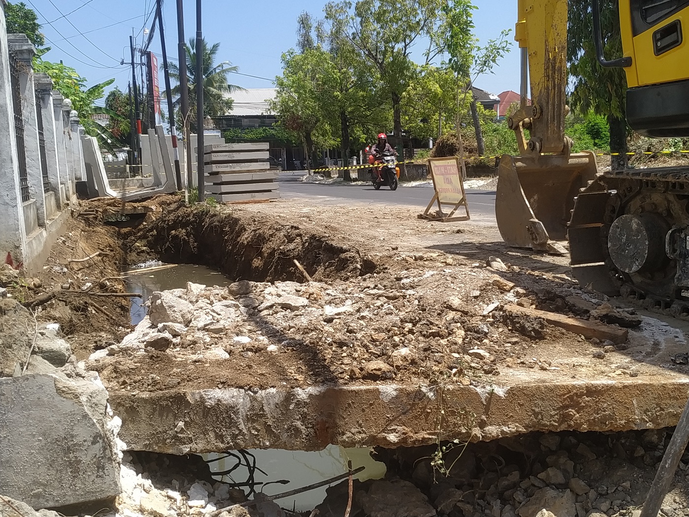 SEDANG DIGARAP: Pengendara sepeda motor melintas di sekitar lokasi proyek peningkatan saluran drainase perkotaan dan lingkungan di Jalan dr Cipto, Desa Pabian, Kecamatan Kota Sumenep, Jumat (15/9). (H