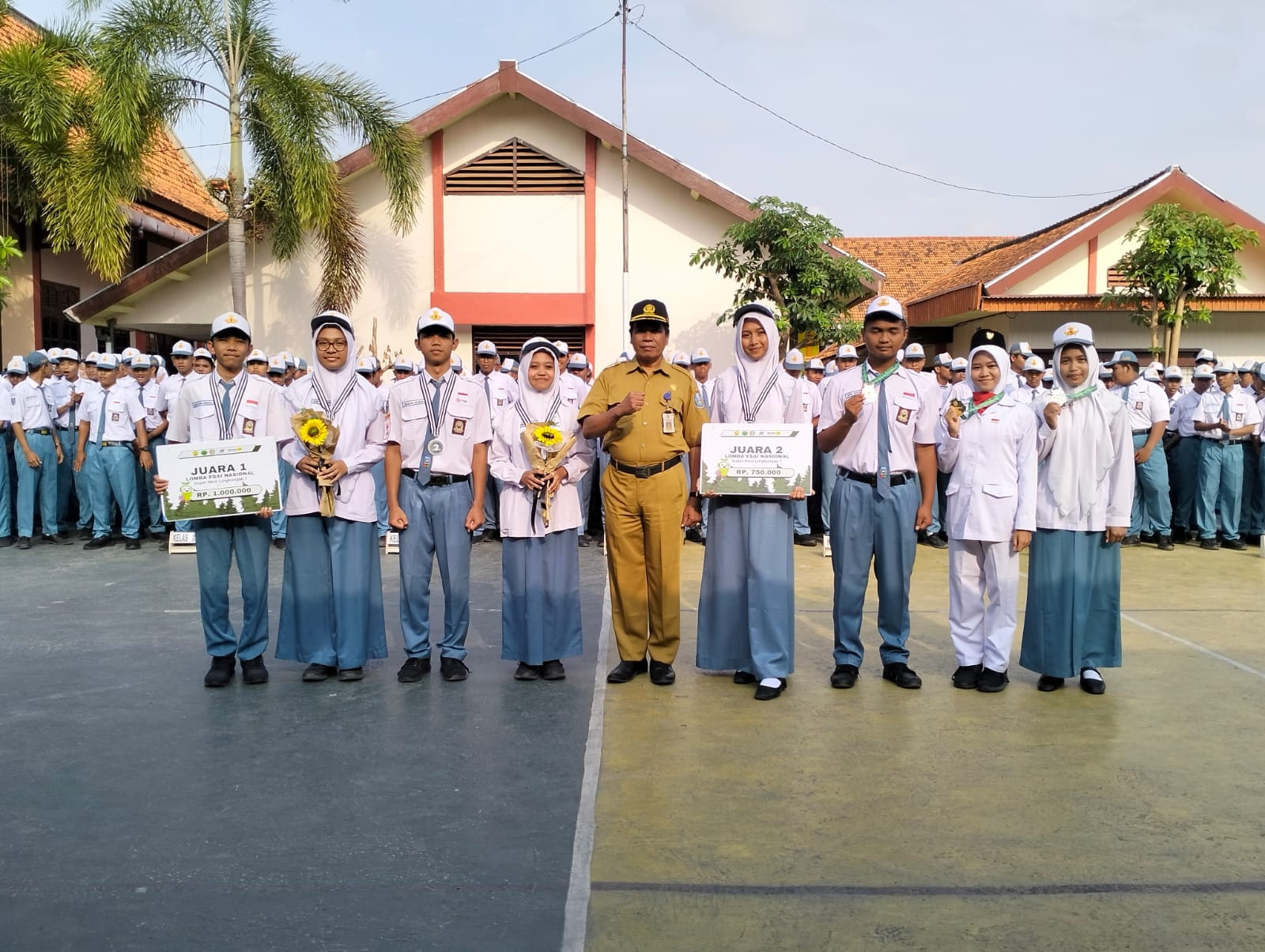 PRODUKTIF: Kepala SMAN 1 Pamekasan Moh. Arifin (tengah) berfoto dengan siswa berprestasi di lapangan sekolah, Senin (18/9). (SMAN 1 PAMEKASAN UNTUK JPRM)