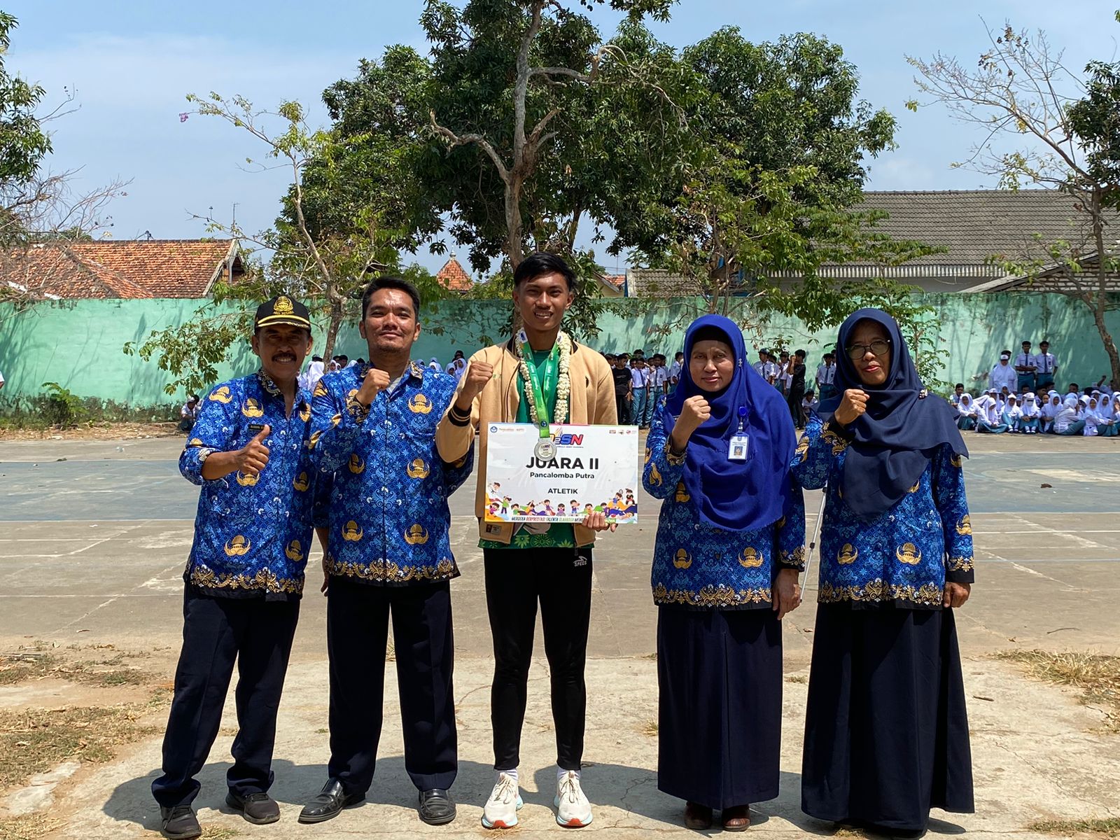 PRESTISIUS: Farid Riyadi (berkalung melati) didampingi Kepala SMAN 4 Pamekasan Faridah dan jajaran guru berpose di lapangan sekolah, Senin (18/9). (AYU LATIFAH/JPRM)